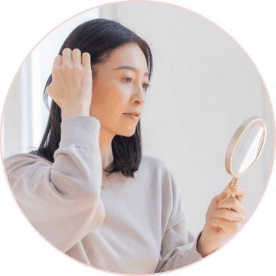 鏡を見て薄毛に悩んでいるイメージ画像